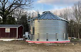 Corrugated water tank next to a shed