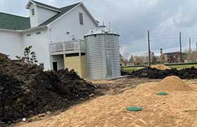 Corrugated tank standing next to a home