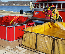 Two frame tanks being utilized by a firefighter for fire supression water storage