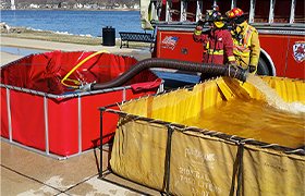 Frame tanks filled with water, used by firefighters during emergency response operations.