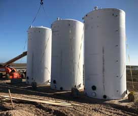 Three oil and fuel tanks being installed on a job site