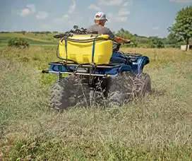 ATV-mounted yellow sprayer tank in use, perfect for small-scale spraying jobs and remote areas.