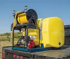 Heavy-duty yellow skid sprayer with a powerful pump and durable hose reel, ideal for high-volume spraying tasks.